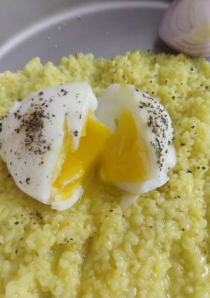 A picture of Dalia made with ghee and half boiled egg.
