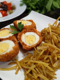 Una foto de Huevos a la escocesa con chorizo y patatas paja