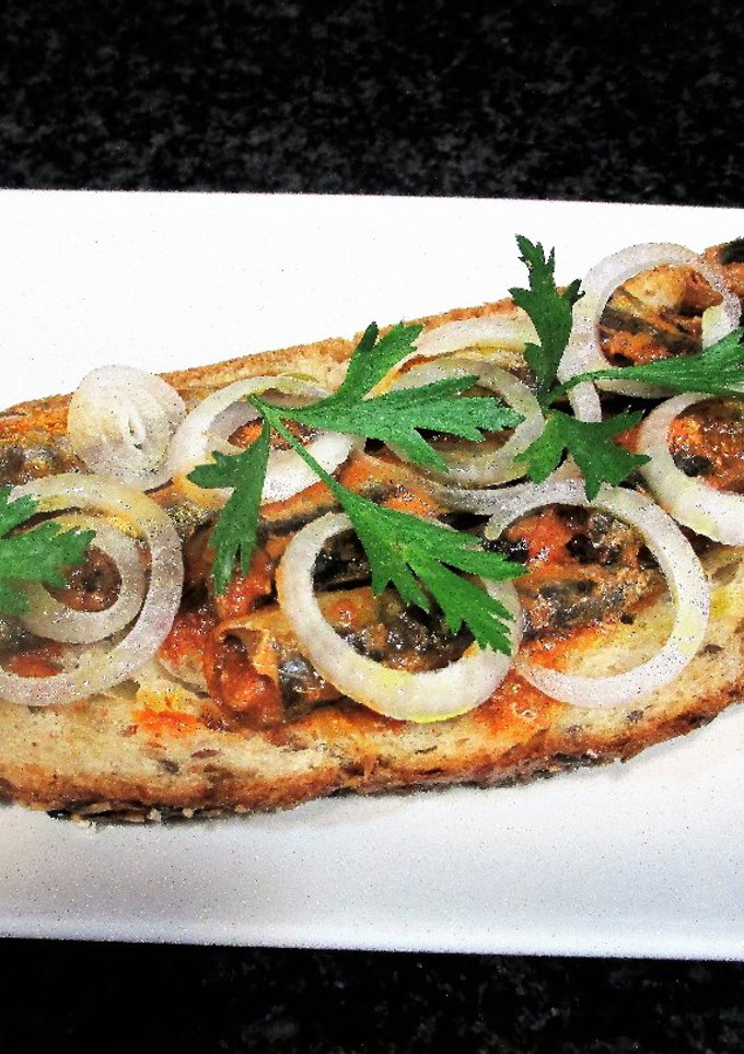 Una foto de Pan Rustik Bakery de semillas con sardinillas en tomates