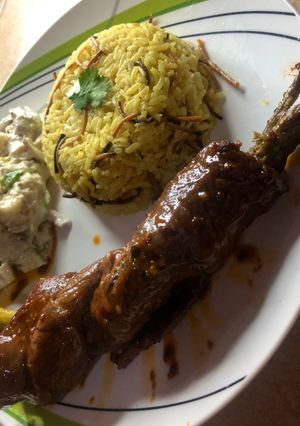 Una foto de (Enrollado de carne con espárragos.) Acompañado con ensalada César y arroz con fideos