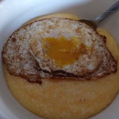 A picture of Cheddar Grits with a Dippy Egg.