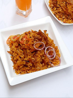 A picture of Palm oil jollof rice with dry fish.