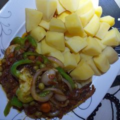 A picture of Boiled potatoes with fish in vegetable sauce.