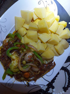 A picture of Boiled potatoes with fish in vegetable sauce.