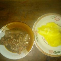 A picture of Okro soup with pomo and yellow garri.