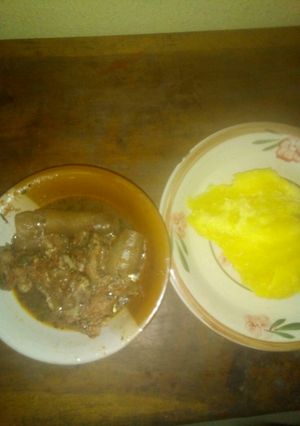 A picture of Okro soup with pomo and yellow garri.