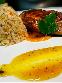 Una foto de Pechuga de pollo en reducción de parchita y arroz con frutos secos