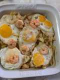 Huevos rotos con langostinos al ajillo y patatas pajas
