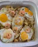 Huevos rotos con langostinos al ajillo y patatas pajas