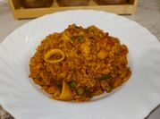 Una foto de cazuela de mariscos con arroz