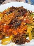 Fettuccine Paglia e Fieno with Porcini Mushrooms, Cherry Tomatoes, and Sausage