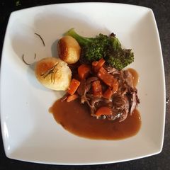 A picture of Slow Cooked Shredded Beef. Roast Spuds and Roasted Broccoli.