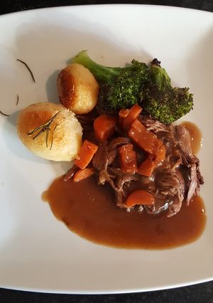 A picture of Slow Cooked Shredded Beef. Roast Spuds and Roasted Broccoli.