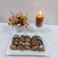 A picture of Banana cinnamon bread rolls with chocolate syrup garnish.