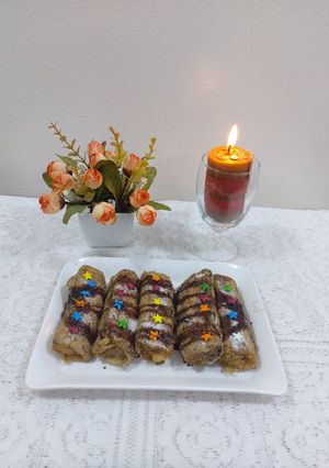 A picture of Banana cinnamon bread rolls with chocolate syrup garnish.