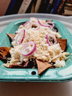 Una foto de Chilaquiles de mole negro con pollo