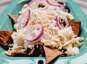 Una foto de Chilaquiles de mole negro con pollo