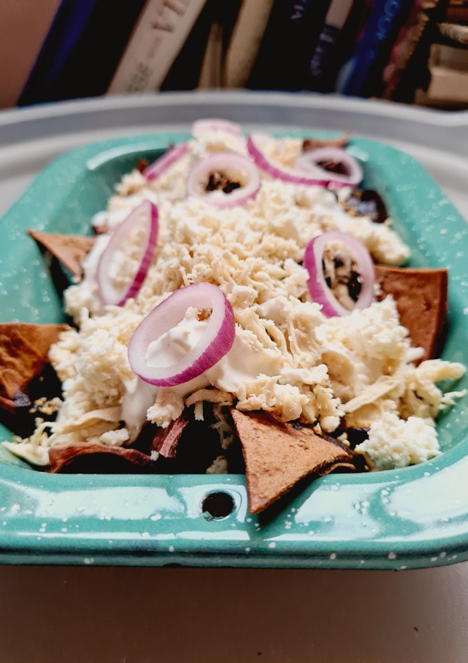Una foto de Chilaquiles de mole negro con pollo