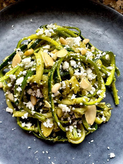 A picture of Zucchini Spaghetti with Basil Pesto, Crumbled Feta, Almonds, and Pine Nuts.