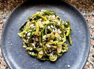Foto di Spaghetti di zucchine al pesto di basilico,con feta sbriciolata, mandorle e pinoli