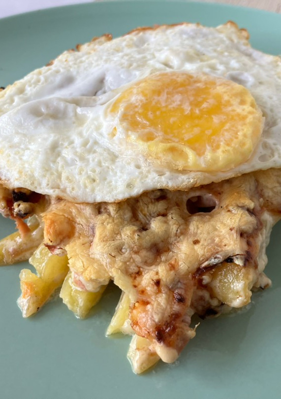 Una foto de Patatas con queso gratinado y salchichas basadas en Foster’s Hollywood