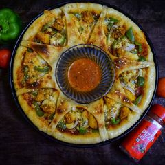 A picture of Chicken tikka ring pizza.