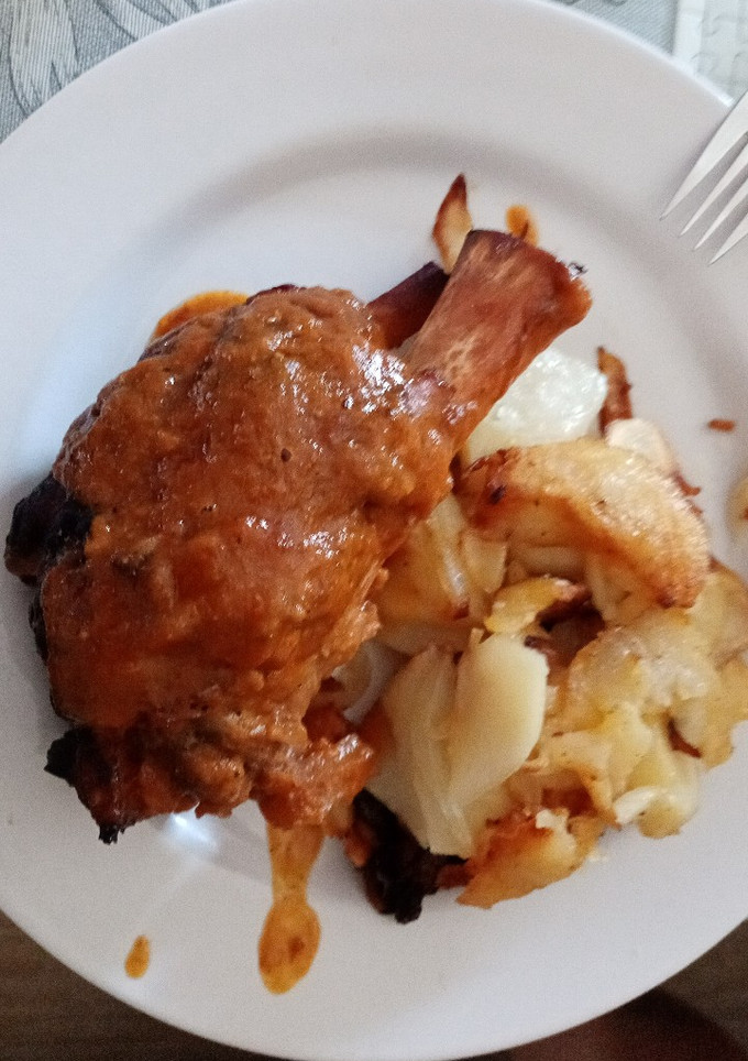 Una foto de Codillo de cerdo al horno en su jugo con patatas a lo pobre
