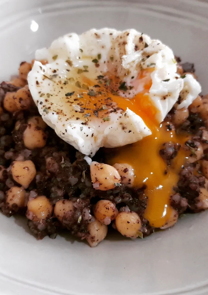 Una foto de Garbanzos salteados con morcilla y huevo poché