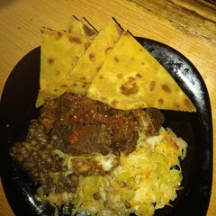A picture of Pumpkin chappati served with beef, lentil stew and steamed cabbage.