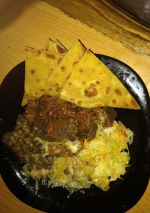 A picture of Pumpkin chappati served with beef, lentil stew and steamed cabbage.