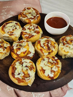 Una foto de 🍕🥓 Pizza rolls 🍥 de panceta y muzzarella 🥓🍕 con salsa picante