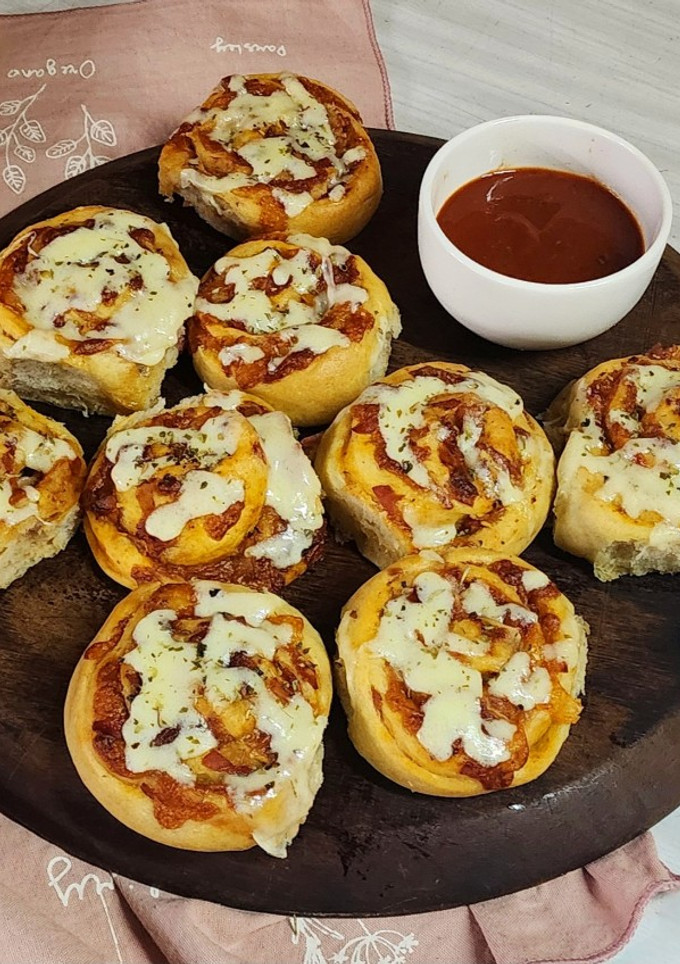 Una foto de 🍕🥓 Pizza rolls 🍥 de panceta y muzzarella 🥓🍕 con salsa picante