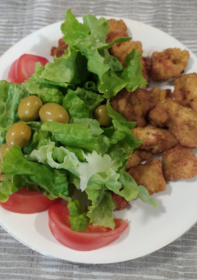 Una foto de Pechuga de pollo a la pimienta rebozada con ensalada