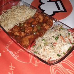 A picture of Chicken Manchurian with egg fried rice and herb noodles.