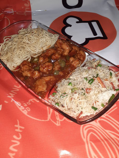 A picture of Chicken Manchurian with egg fried rice and herb noodles.
