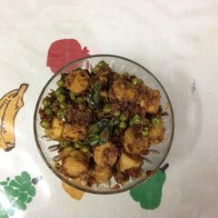 A picture of Chicken sausages with green peas.