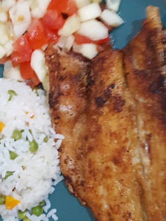 Una foto de Lubina frita acompañada con arroz blanco y ensalada de pepino