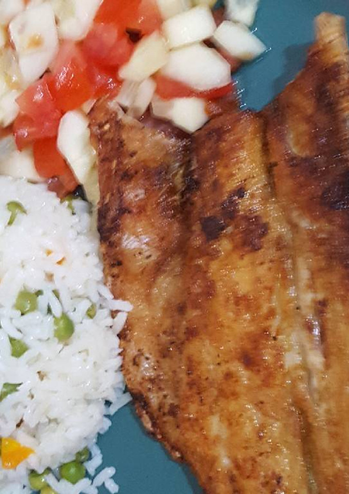 Una foto de Lubina frita acompañada con arroz blanco y ensalada de pepino