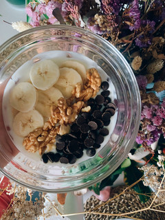 Una foto de Yogur con plátano, nueces y gotitas de cacao negro