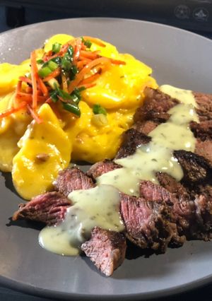 A picture of Seared Strip w/ Creamy Cilantro Lime Sauce & Scalloped Potatoes.
