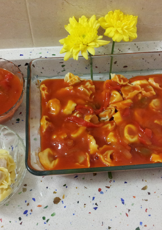 Una foto de Cappellettis rellenos de jamón con salsa de tomate casera