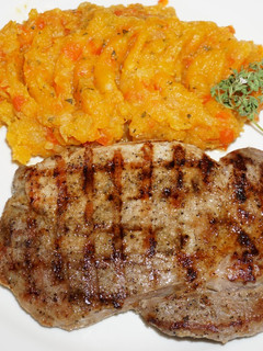 Una foto de CHULETAS DE CERDO GRILLADAS AL COMINO, PURE DE ZAPALLO CON PIMENTON ROJO
