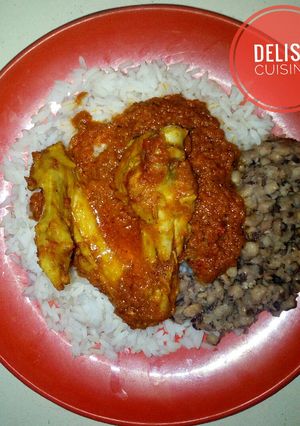 A picture of Rice and beans with chicken stew.