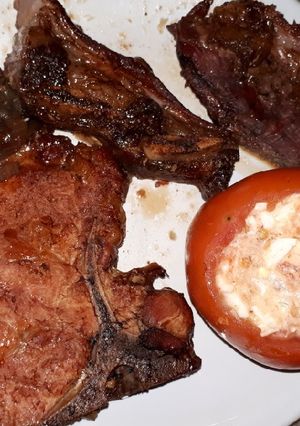 Una foto de Asado, vacío y chuletas de cerdo con tomates rellenos