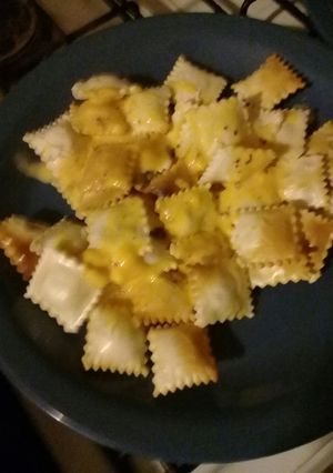 Una foto de Ravioles fritos con salsa de cheddar