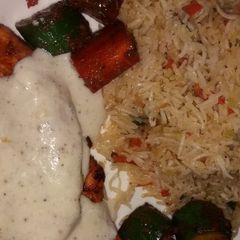 A picture of Grilled chicken with tarragon sauce served with fried rice.