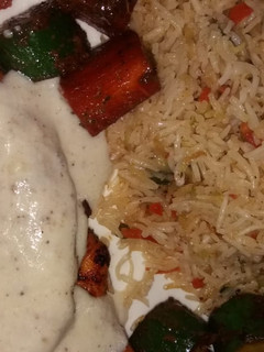 A picture of Grilled chicken with tarragon sauce served with fried rice.