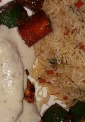 A picture of Grilled chicken with tarragon sauce served with fried rice.