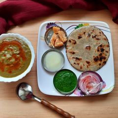 A picture of Bajra Roti with saag/Jaggery/chutney.