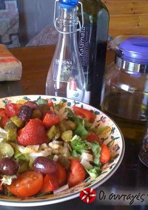 A picture of Green salad with parmezan and strawberries.